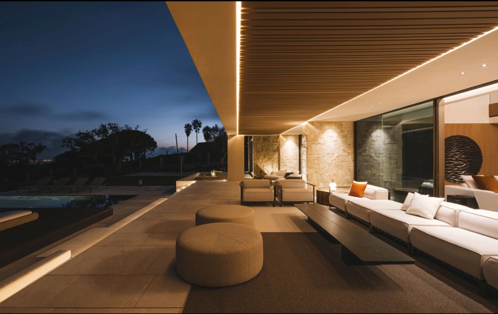 Coastal estate illuminated at twilight with linear architectural lighting